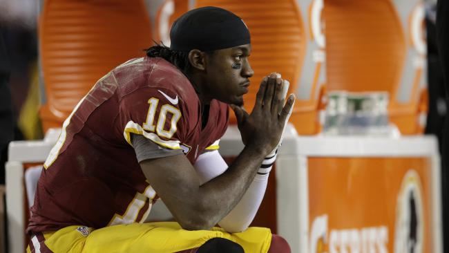 Washington Redskins quarterback Robert Griffin III sits on the bench after a knee injury during an NFL wild card playoff football game against the Seattle Seahawks in Landover, Md., Sunday, Jan. 6, 2013. The Seahawks defeated the Redskins 24-14. (AP Photo/Evan Vucci)